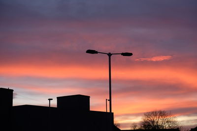 Low angle view of silhouette street light against sky