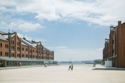 Buildings by street against sky in city