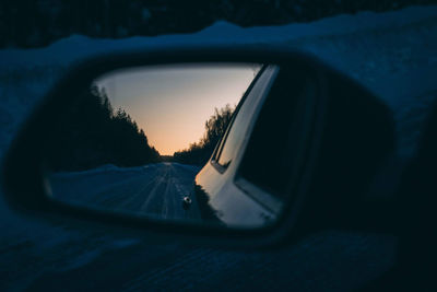 Reflection of sky on side-view mirror of car