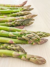 High angle view of green asparagus on light wood underground 