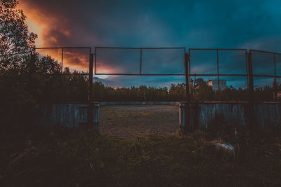 Field against cloudy sky during sunset