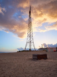 Low angle view of communications tower on field against sky