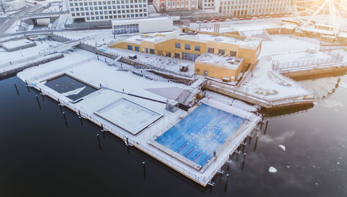 High angle view of swimming pool by lake against buildings