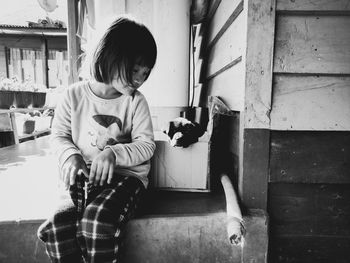 Girl sitting by puppy in cardboard box