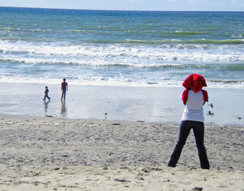 People at beach against sky