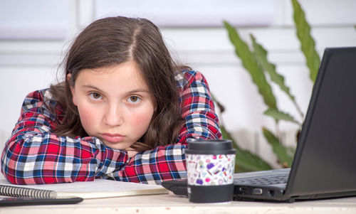 Portrait of girl sitting on table