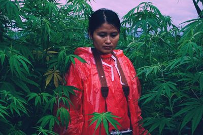 Portrait of woman standing against plants