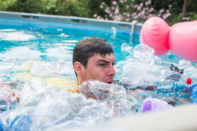 Portrait of young man swimming in pool
