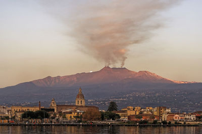 Panorama of the city of riposto with the background of the erupting etna