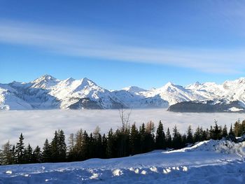 Scenic view of snowcapped mountains against blue sky