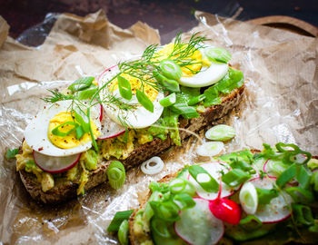 High angle view of open faced sandwiches on wax paper