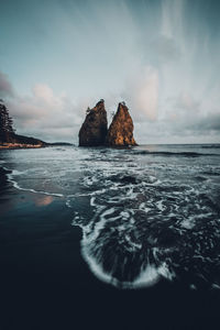 Rocks in sea against sky