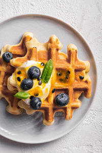 Breakfast with waffles with blueberries and syrup on a plates