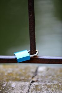 Close-up of rusty metal railing against river