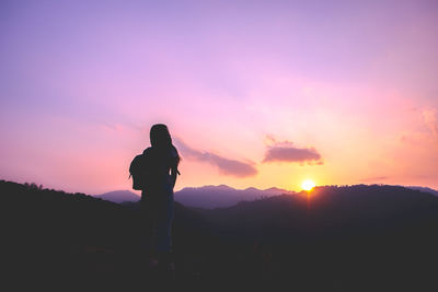 Silhouette man standing against sky during sunset