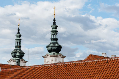 Low angle view of church against cloudy sky in city