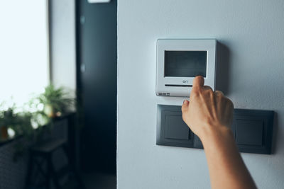 Woman controlling office with digital touch screen panel installed on the wall in office. smart home