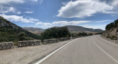 Empty road by mountains against sky in southern spain.