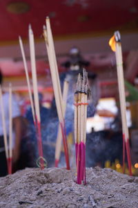 Close-up of incenses burning at temple 