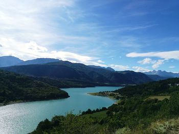 Scenic view of river and mountains against sky