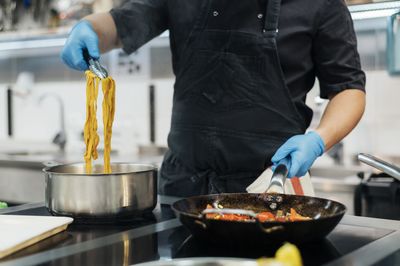 Midsection of man preparing food in kitchen