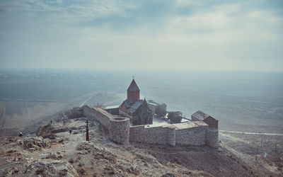 Old building on landscape against sky