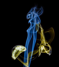 Close-up of illuminated smoke against black background