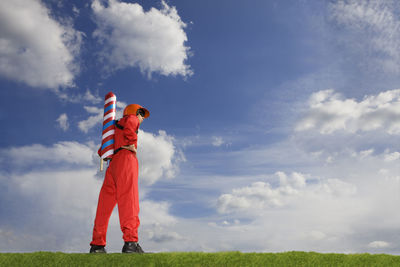 Boy standing on field against sky