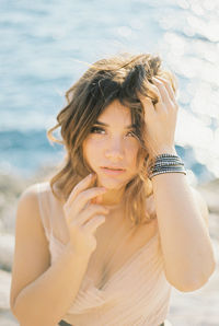 Portrait of young woman standing at beach