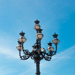 Low angle view of street light against blue sky