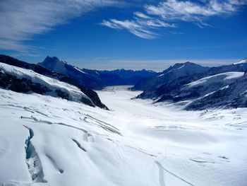 Scenic view of snowcapped mountains against blue sky