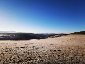 Scenic view of desert against clear blue sky