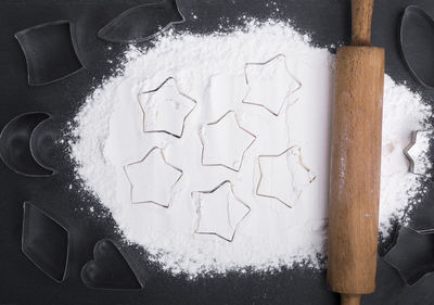 Close-up of flour and pastry cutter on table