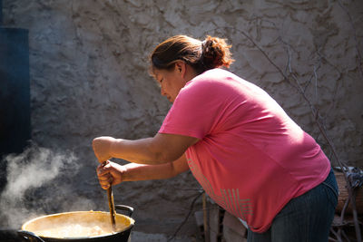 Portrait of woman preparing food outdoors