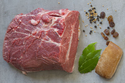 Directly above shot of red meat by spices on cutting board