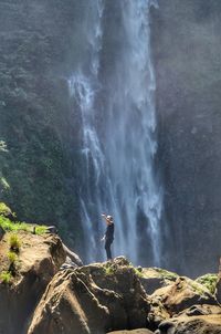 Man taking selfie against waterfall
