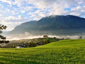 Scenic view of field and mountains against sky