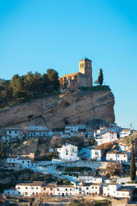 Buildings in city against clear blue sky