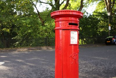 Red mailbox on road in city