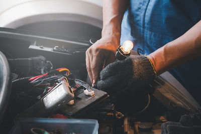 Midsection of repairman working at garage