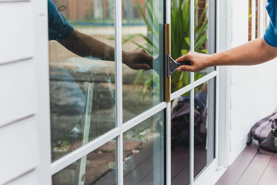 Worker use scraper cleaning window before installing tinting film.