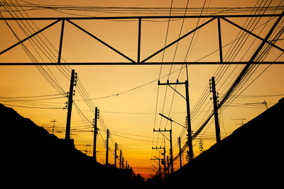 Silhouette electricity pylon against sky during sunset