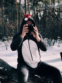 Midsection of woman photographing in snow