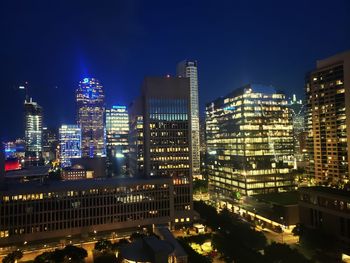 Illuminated buildings in city against sky at night