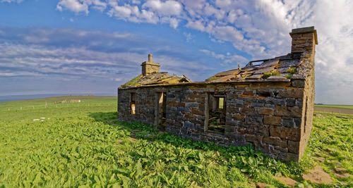 Built structure on field against sky