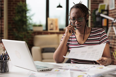 Businesswoman using laptop while sitting at office