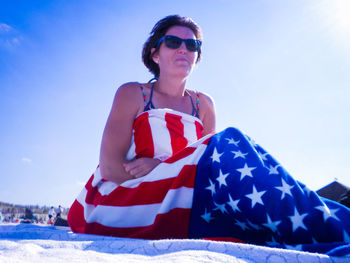 Low angle view of young woman against clear sky