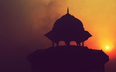 Low angle view of built structure at sunset