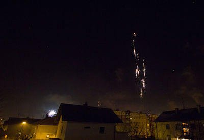 Low angle view of illuminated city against sky at night