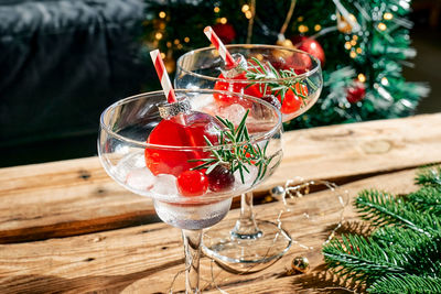 Christmas drink mimosa, punch or cranberry margarita cocktail serving in christmas ornaments